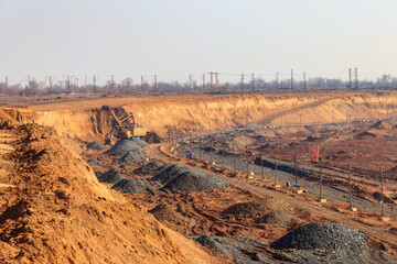 Big yellow excavator working in iron ore quarry