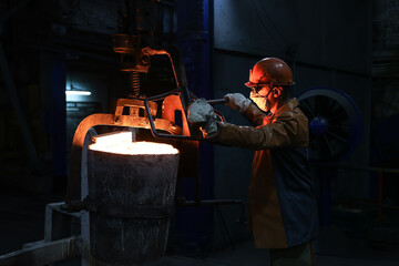 A steelmaker pours pig iron from a blast furnace, sparks and splashes of hot metal fly.