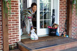 © Gerald R Carter Jr/Creative Flame - Black woman grabs food delivered to front door at home