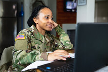 Happy Military Woman Listening To Family While Working From Home At Laptop