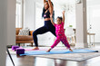© Gerald R Carter Jr/Creative Flame - Black Mother and daughter doing yoga in family room, warrior pose