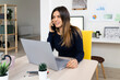 © Giorgio Fochesato/Westend61 - Smiling female freelancer on phone call while sitting by laptop at home