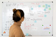 © Giorgio Fochesato/Westend61 - Woman analyzing mathematical formula written on whiteboard in living room