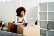 © Giorgio Fochesato/Westend61 - Afro woman with hand on chin day dreaming while standing by laptop in new loft apartment