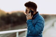 © Oriol Castell√≥ Arroyo/Westend61 - Young man in blue jacket talking on smart phone during sunset