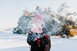 © Manu Reyes/Westend61 - Playful woman blowing snow while enjoying vacation at countryside