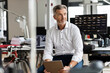 © peter scholl/Westend61 - Mature businessman with digital tablet looking away while sitting at office