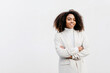 © Tania Cervi√°n/Westend61 - Smiling afro young woman with arms crossed standing against white wall