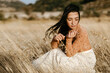 © Tania Cervi√°n/Westend61 - Young woman contemplating while sitting amidst gfrass in field during windy day