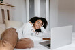 © Tania Cervi√°n/Westend61 - Smiling woman using laptop while lying on bed at home