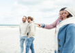 © Uwe Umst√§tter/Westend61 - Group of adult friends standing and talking on coastal beach