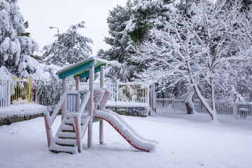 Winter morning snow covered children's playground in the Athens city, Greece, 16th of February 2021.