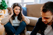 © Jake Jakab/ADDICTIVE STOCK - Smiling female musician listening to music in headphones while sitting at home with boyfriend and composing songs together