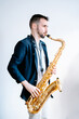 © Jake Jakab/ADDICTIVE STOCK - Side view of creative male musician playing saxophone while standing on white background and looking away