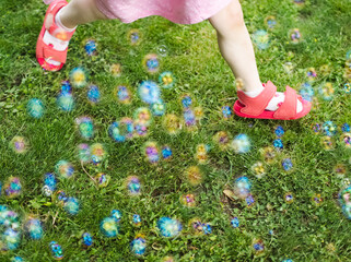 Wall Mural - Little Girl Running Through Soap Bubbles