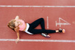 © Manuel Ruiz Alba/ADDICTIVE STOCK - From above blonde young sportswoman sitting on the floor resting on tracking field