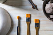 © Pablo Gracia/ADDICTIVE STOCK - Top view set of pottery and painting brushes placed on wooden table with bowl of clay and ceramic pot in workshop