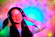 Stock Photo Of Happy Asian Woman Listening To Music In Her Room With Colorful Lights.