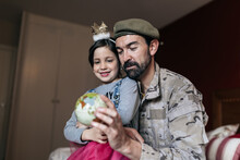 From Below Of Positive Soldier Talking To Daughter And Pointing At Place At Globe Before Going To Serve In Army