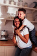 © iordani - young pretty african american mother with little cute son on kitchen in morning preparing breakfast, lifestyle people concept