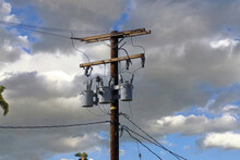 Low Angle View Of A Modern Electricity Pylon And Power Lines Under Blue Sky