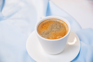 white cup of coffee on blue cloth