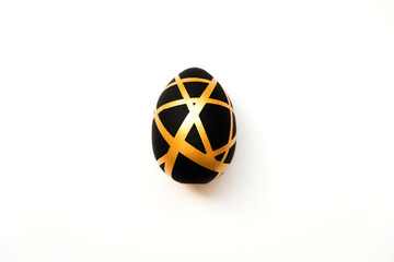 Easter golden egg with geometric black pattern isolated on white background. Minimal easter concept. Happy Easter card with copy space for text. Concept for banner, flyer, invitation, greeting card.