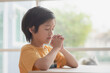 © lalalululala - Cute Asian child boy praying with eyes closed in the mornin