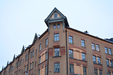 Poster - Low angle of an old building with glass windows under a white sky background