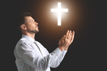 Wall Mural - Religious man praying on dark background