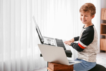 Wall Mural - Little boy taking music lessons online at home