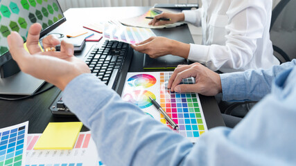 Poster - graphic designer team working on web design using color swatches editing artwork using tablet and a 