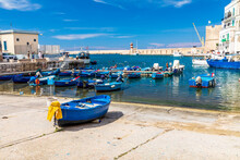 Italy, Apulia, Metropolitan City Of Bari, Monopoli. Porto Di Monopoli. Small Blue Fishing Boats Tied Up In Port.