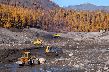 Wall Mural - Wheel loaders and bulldozers in operation in an industrial mountainous area