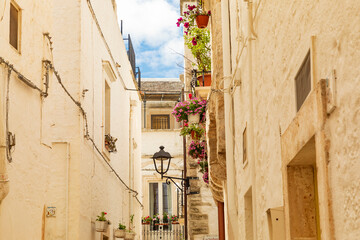 Canvas Print - Italy, Apulia, Metropolitan City of Bari, Locorotondo. Looking up at stucco buildings in a narrow alley.