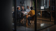 © Gorodenkoff - Young Creative Team Meeting with Business Partners in Conference Room Behind Glass Walls in Agency. Colleagues Sit Behind Conference Table and Discuss Business Opportunities, Growth and Development.