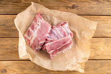 Chopped pieces of raw pork ribs on craft paper.