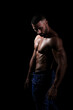 © Cristina Trujillo - El cuerpo masculino perfecto - Impresionante culturista posando. Chico joven musculado. Aislado sobre fondo negro. Espacio para texto