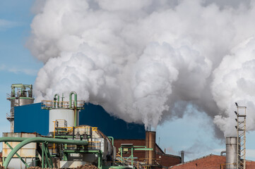 Sugar production factory with chimneys expelling smoke outside