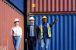 © ake1150 - African american foreman is explaining the various sections of the container depot terminal to a caucasian man manager, with a female secretary next to him.