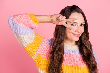 Wall Mural - Portrait of attractive cheerful brown-haired girl showing v-sign near eye having fun isolated over pink pastel color background