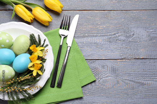 Obraz Dibond Festive Easter table setting with eggs on grey wooden background, flat lay. Space for text