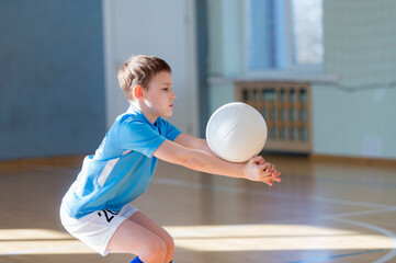 School kid playing volleyball in a physical education lesson. Safe back to school during pandemic concept