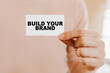© Daria Lukoiko - Man holding a business card with Build Your Brand