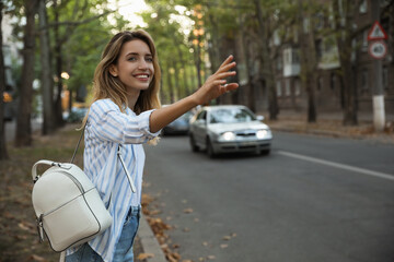 Canvas Print - Young woman catching taxi on city street