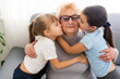 Happy middle-aged mature grandma and little preschooler two granddaughters having fun playing at home