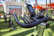 A view of several stationary bikes on an outdoors lawn for a cycle fitness class.