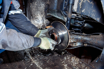 installing a new brake disc of a car in the garage