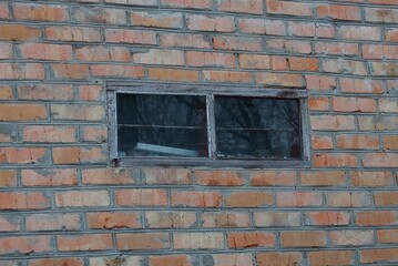 Poster - one small rectangular old window on a brown bricks wall of a house on the street