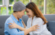 © Bangkok Click Studio - Older Asian woman patient covered the head with clothes effect from chemo treatment in cancer cure process touch her daughter's forehead with happy